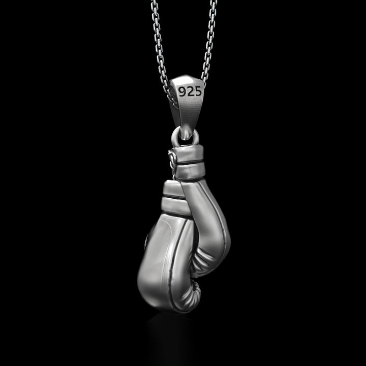 Silver boxing gloves pendant on a chain with '925' stamp against a black background
