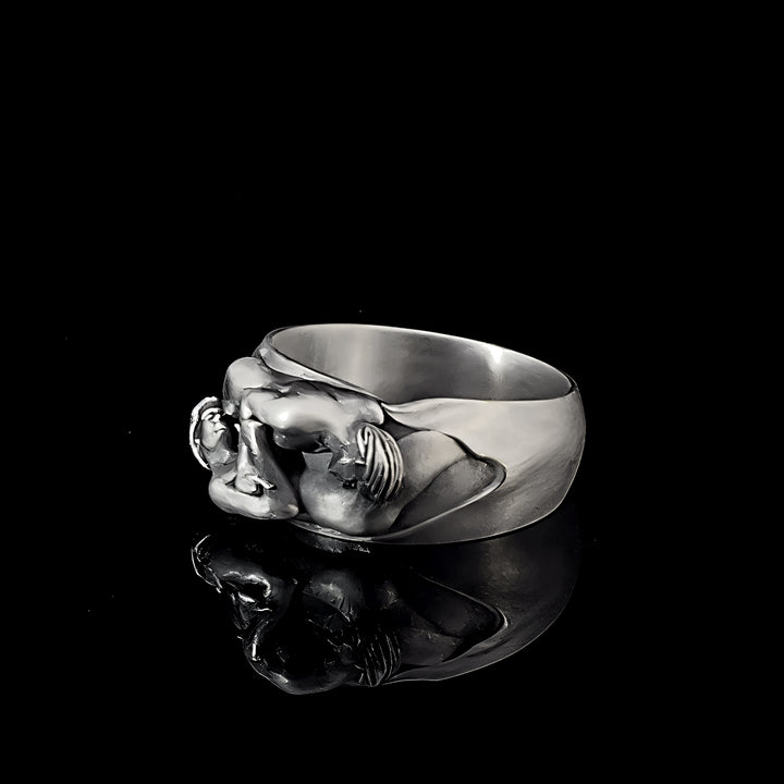 Silver ring with a men’s love design on a black background