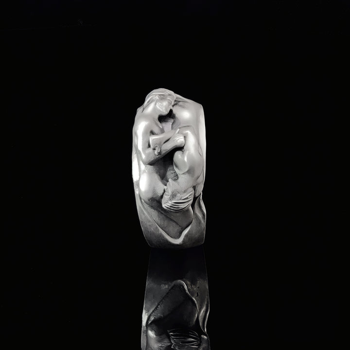 Silver ring with a detailed gay couple design on a black background