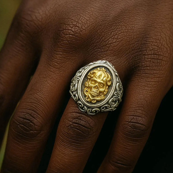 Gold and silver skull ring on a person's finger
