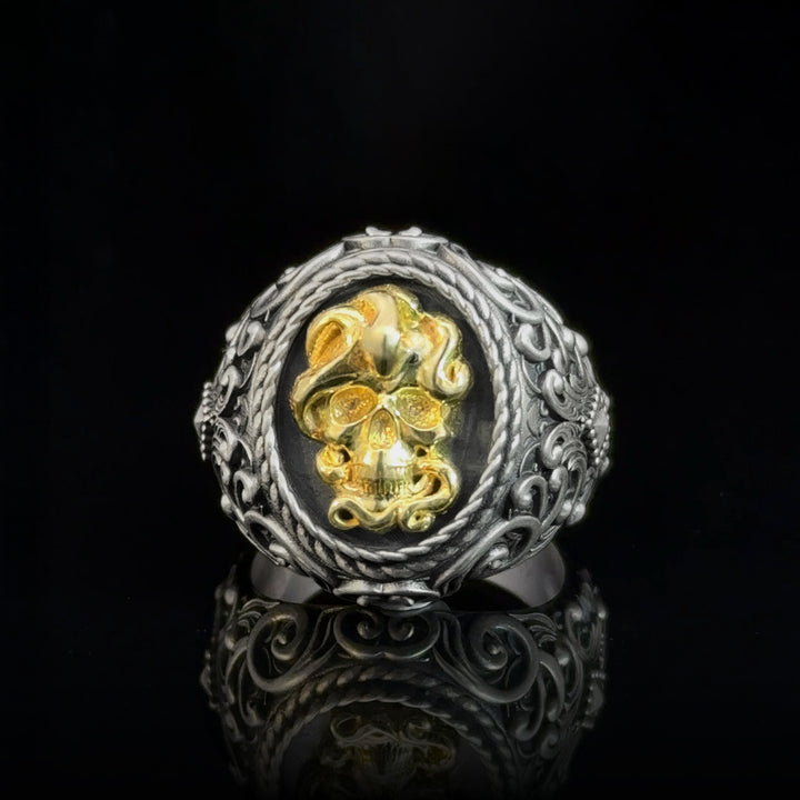 Gothic punk men’s ring with gold and silver skull design on a black background