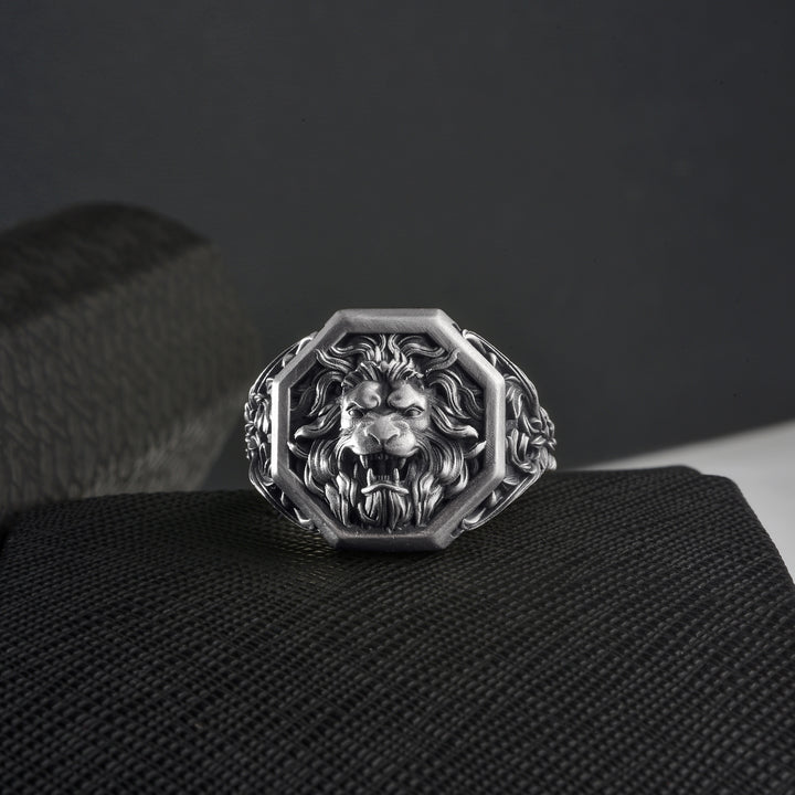 Gothic lion head ring on a textured black surface with a dark background