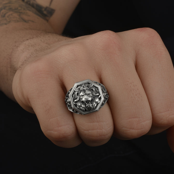 Royal lion ring on a person's finger against a dark background