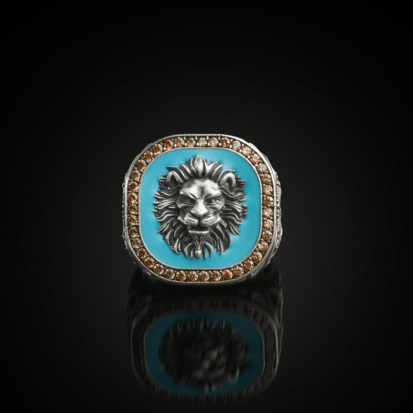 Ring with lion head sealed in turquoise background on a black reflective surface