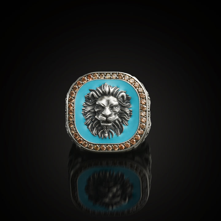 Ring with lion head sealed in turquoise background on a black reflective surface