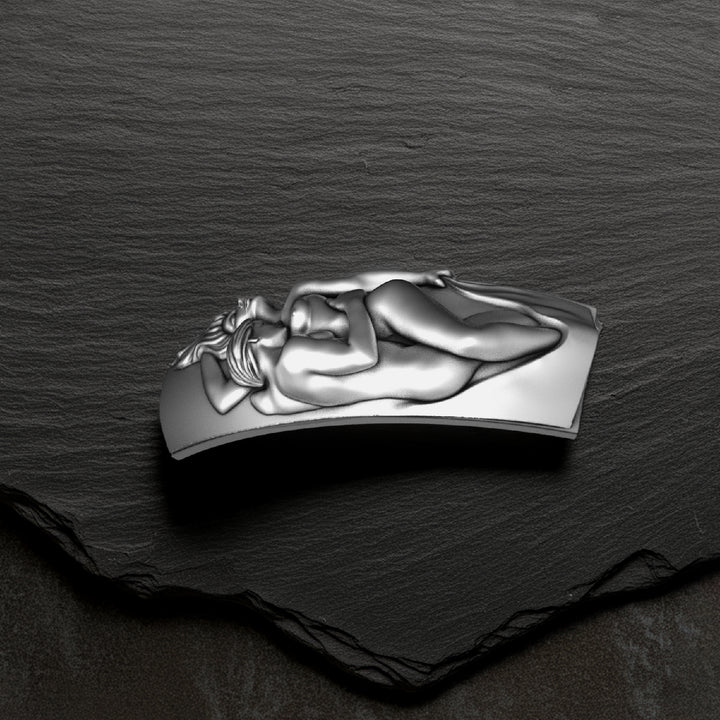 Silver couple necklace pendant on a dark stone surface