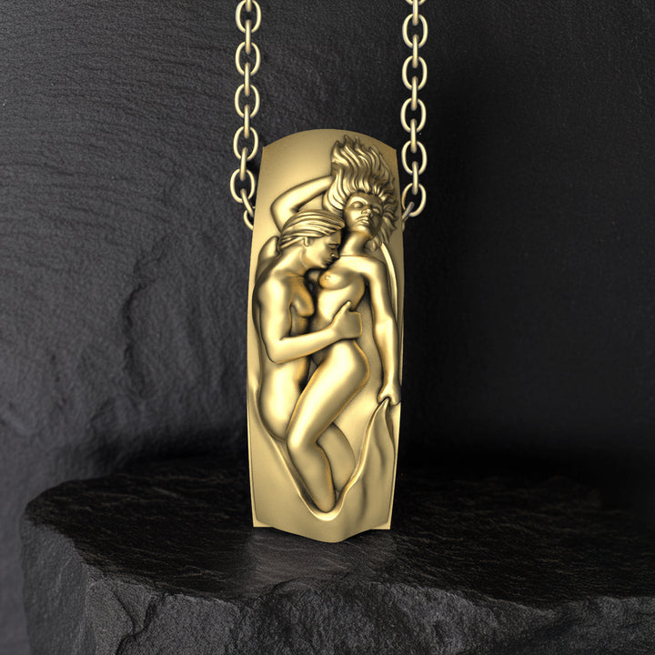 Gold pendant with a design of two romantic lovers on a dark background