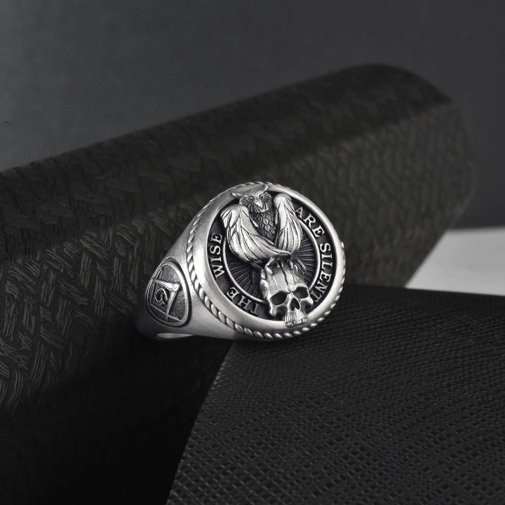 Silver masonic ring with an occult symbols design on a textured black surface