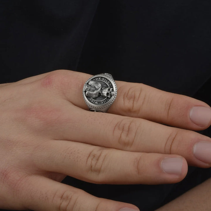 Secret society signet ring with a detailed design on a person's finger against a black background