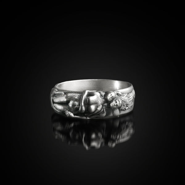Sterling silver ring with hugging lovers design on a black background