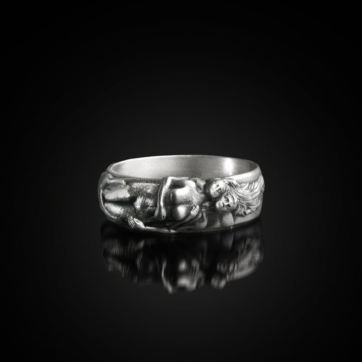 Sterling silver ring with hugging lovers design on a black background