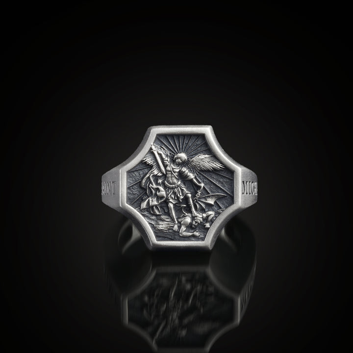 Sterling silver signet ring with a detailed St Michael design on a black background