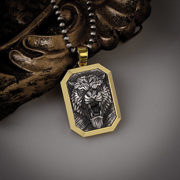 Gold and silver pendant with a fierce tiger design on a dark background